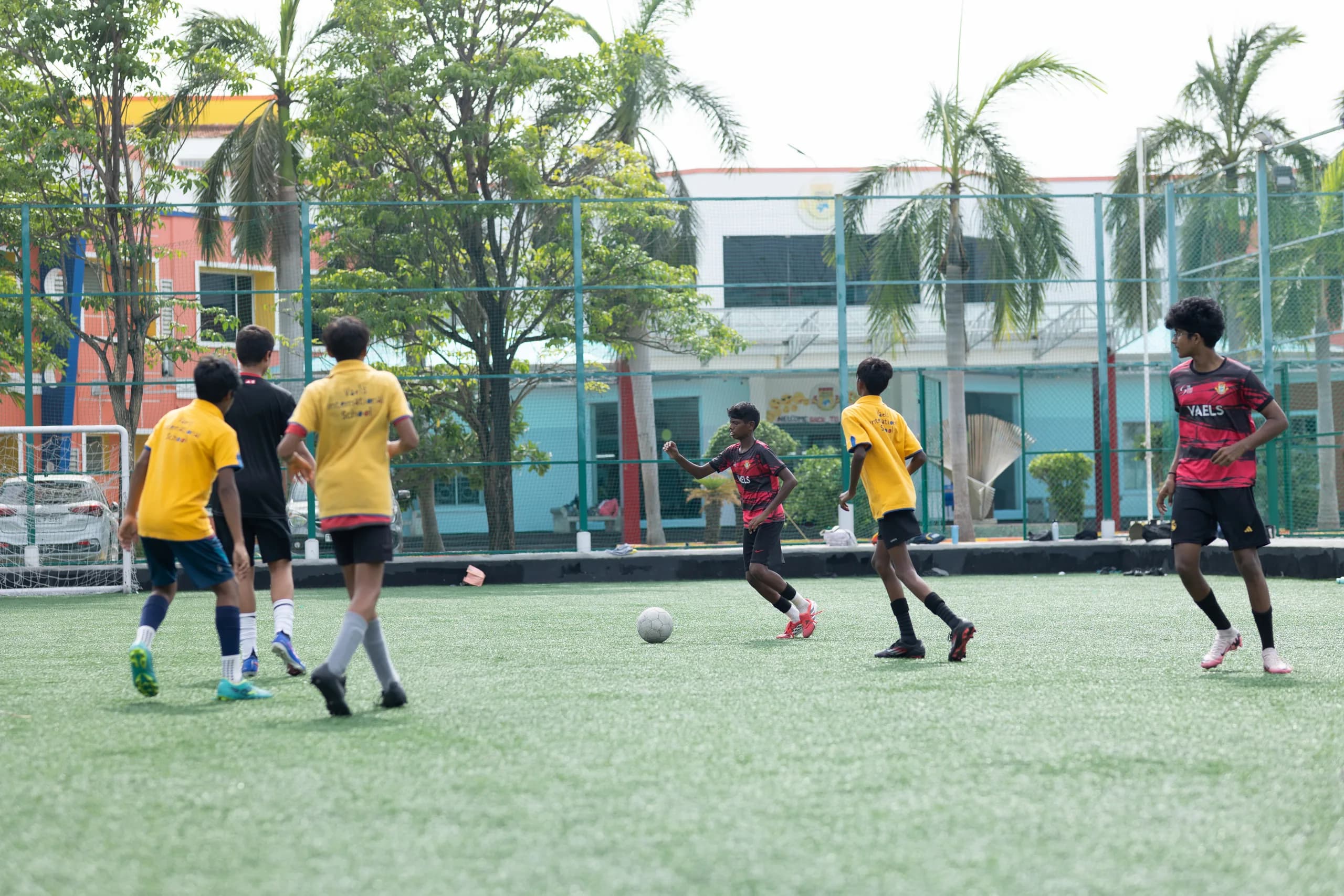 Boys football team practising passing drills on the school field