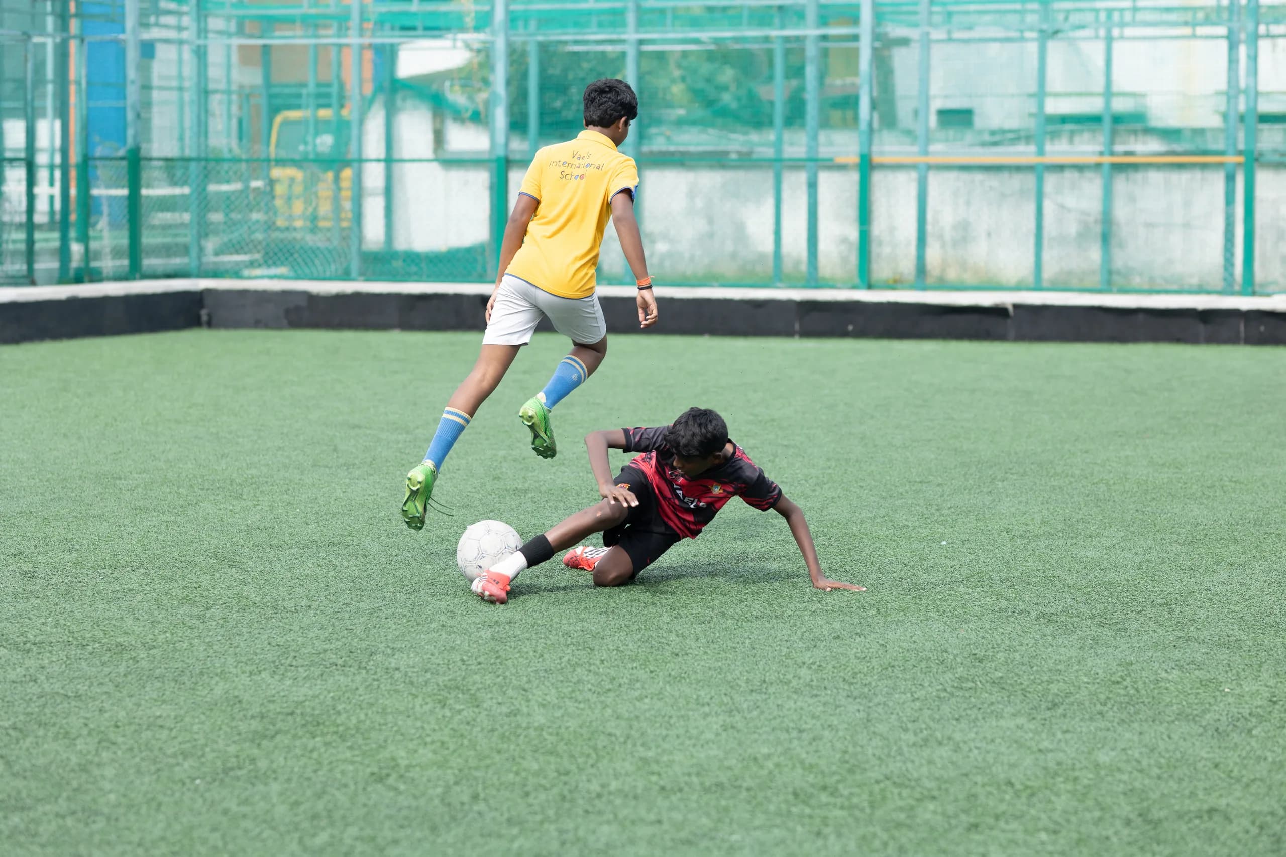 Boys football team celebrating a goal on the school grounds