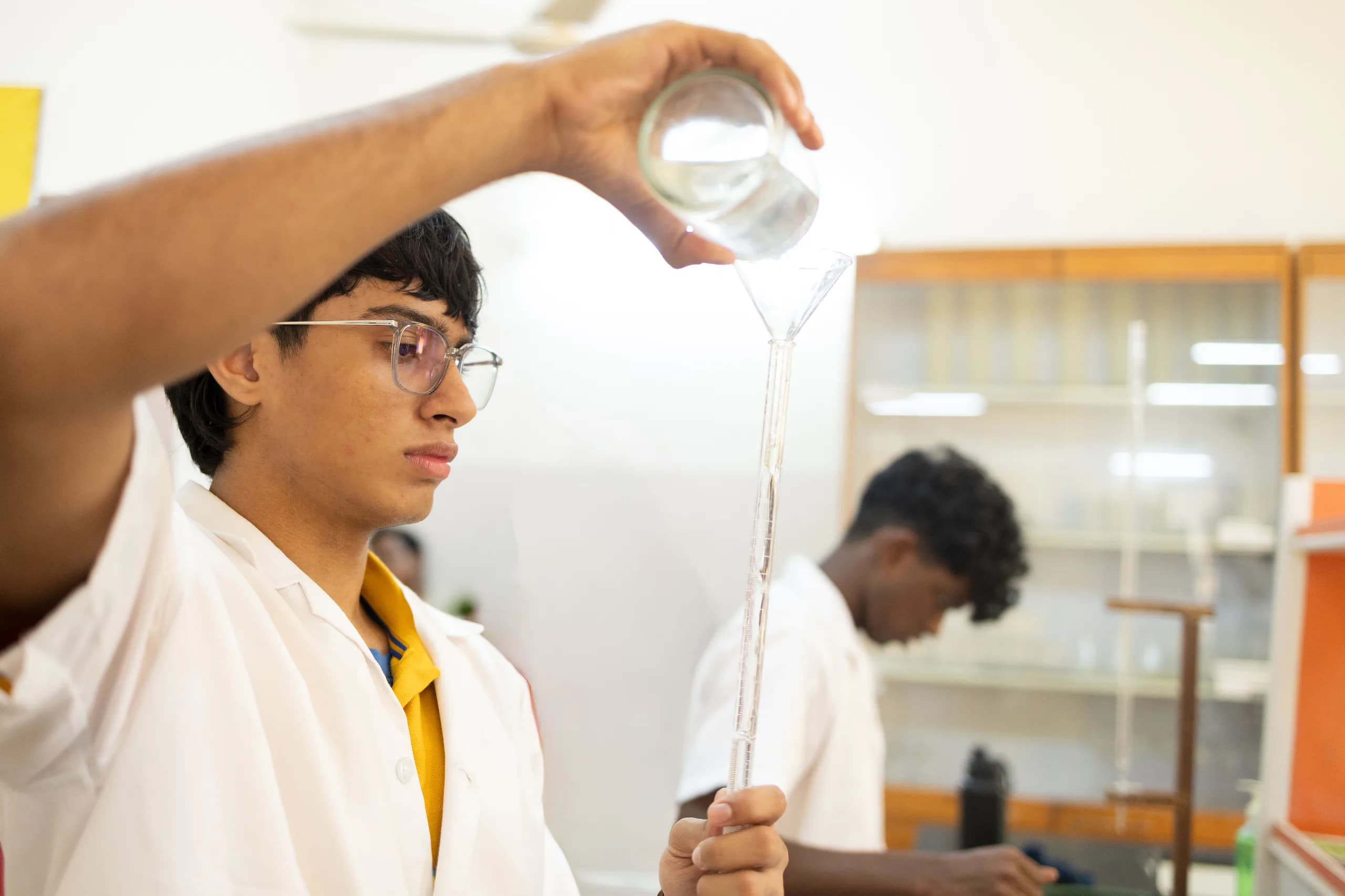 A student demonstrating proper lab technique in chemistry class