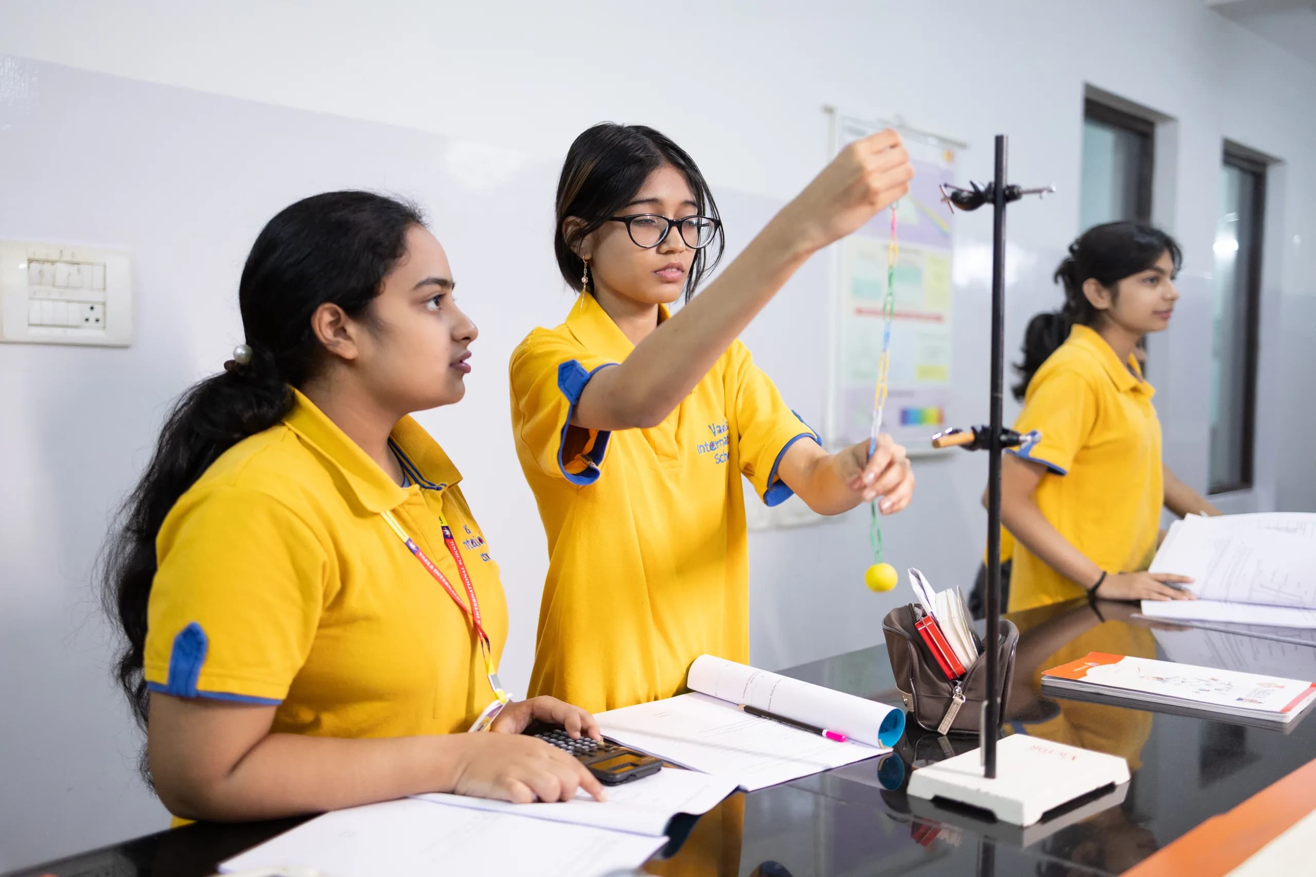 A focused student conducting a physics experiment at Vaels