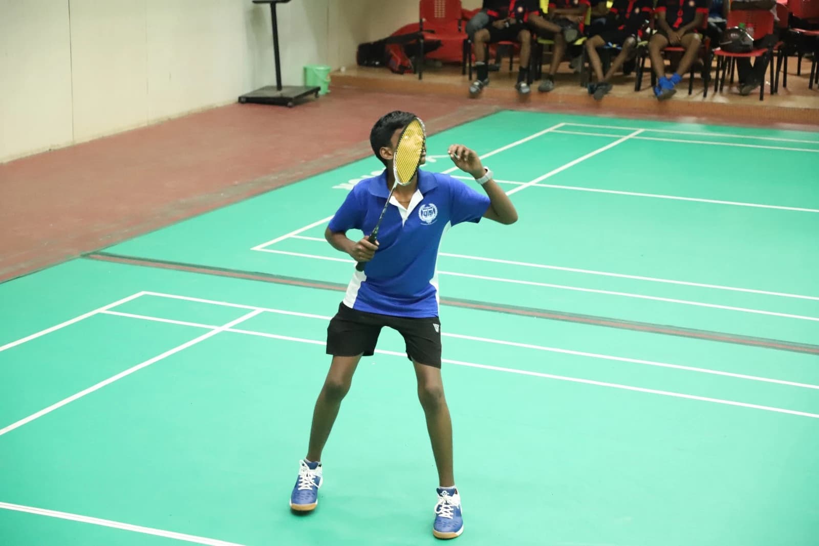 Student in ready position during badminton practice
