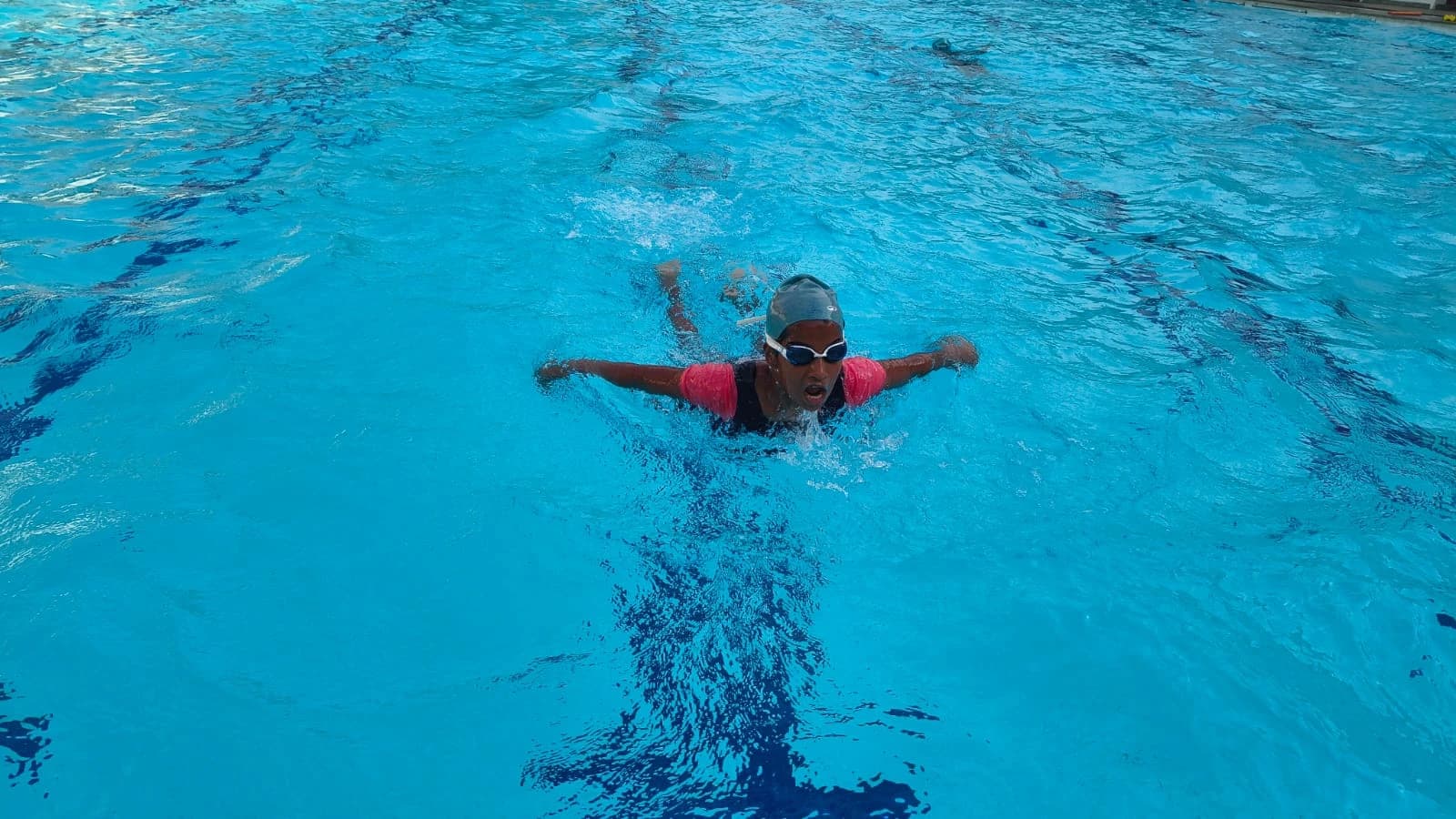 Student performing butterfly stroke in the school swimming pool